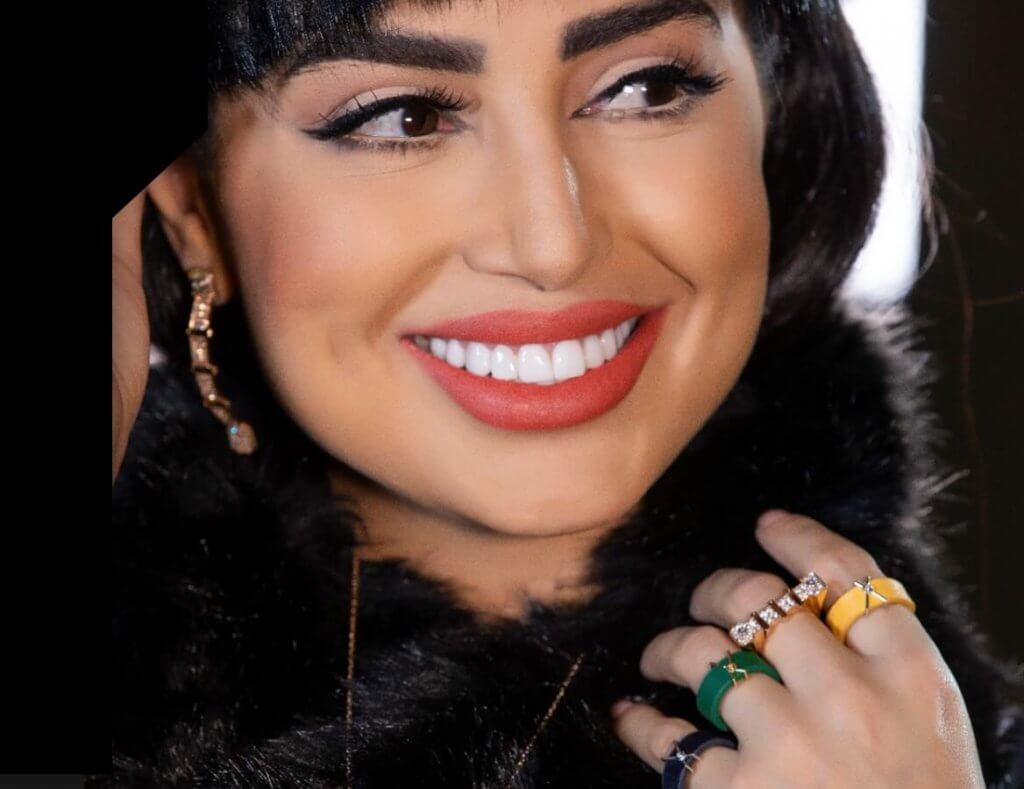 Smiling woman wearing Wazna coloured leather and gold rings and a gold earring